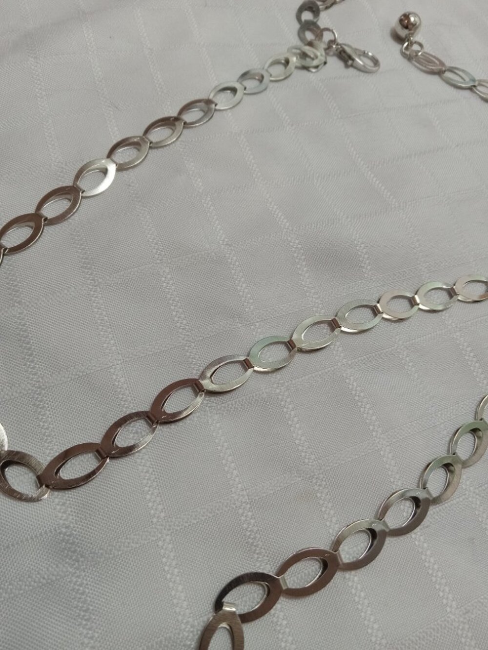 A pretty silver-colored belt with a thin, large-link chain 36 inches